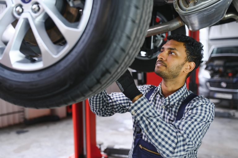 Indian,car,mechanic,standing,and,working,in,service,station.,car